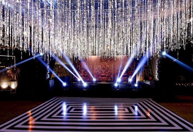 a stage with lights and chandeliers hanging from it's ceiling is lit up