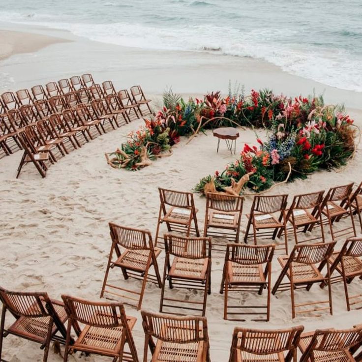 an empty beach with chairs and flowers arranged in the shape of a heart