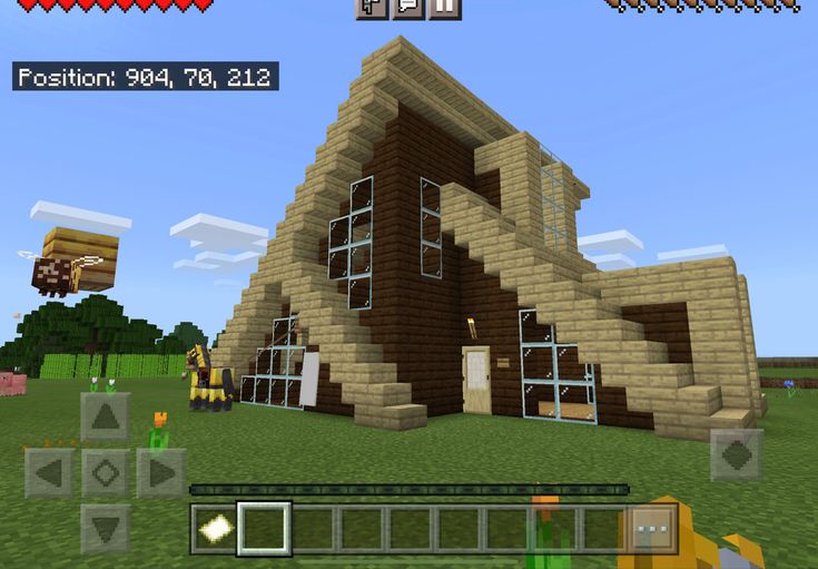 an image of a minecraft house in the middle of a field with people around it