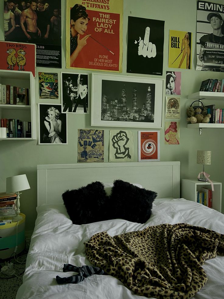 a bedroom with posters on the wall and a white bed in front of it's headboard