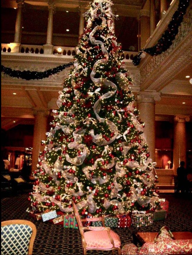 a decorated christmas tree in the lobby of a hotel