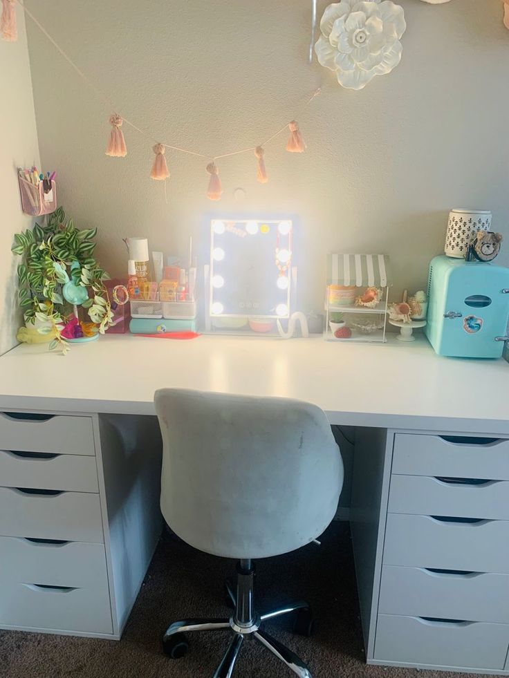 a white desk topped with drawers and a mirror next to a wall filled with decorations