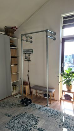 a room with a bed, bookcases and other items on the floor in front of a window