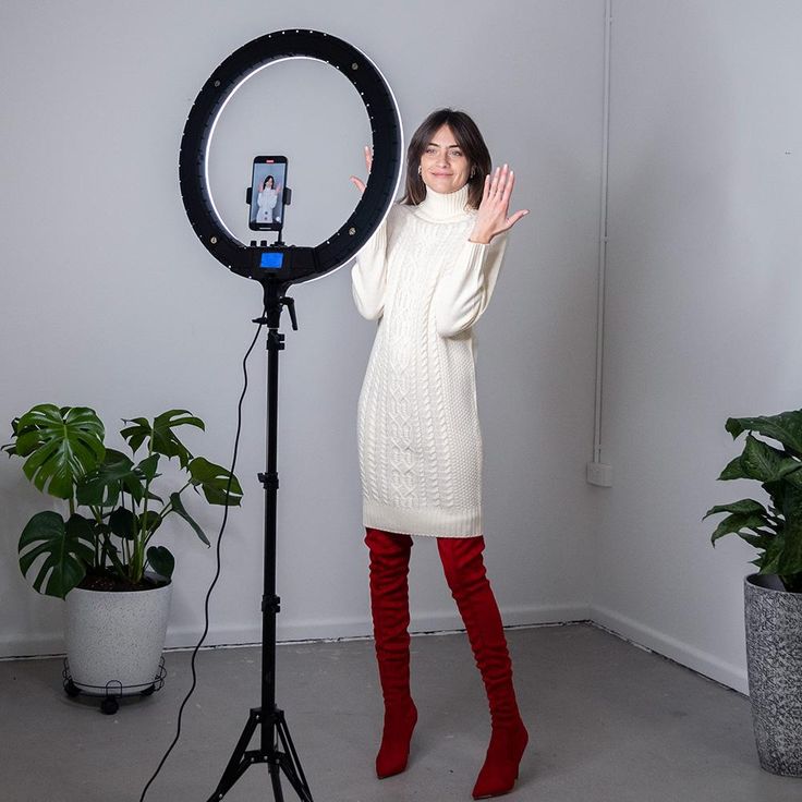 a woman standing in front of a camera and holding her hands up to the side