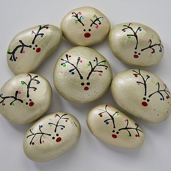 six white painted rocks with designs on them