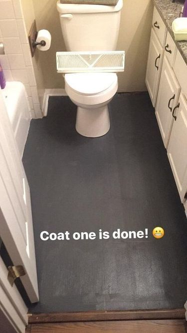 a bathroom that has a black floor and white cabinets with the words coat one is done