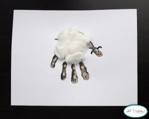 an animal made out of fake wool on top of a piece of paper with scissors