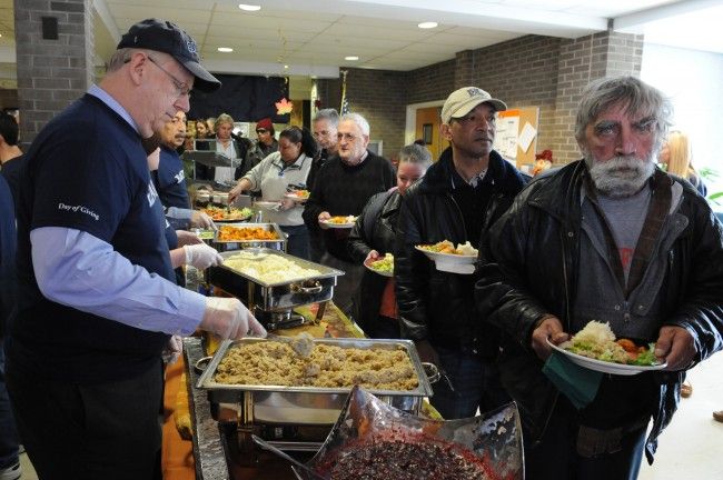 several men are serving themselves food from trays in a buffet line at a restaurant