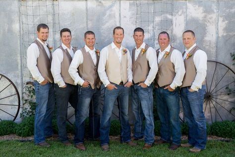 a group of men standing next to each other in front of a wall with wheels