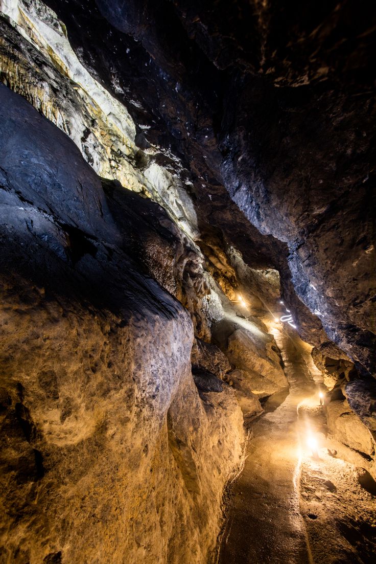 the light shines brightly in this cave like area with large rocks and narrow paths