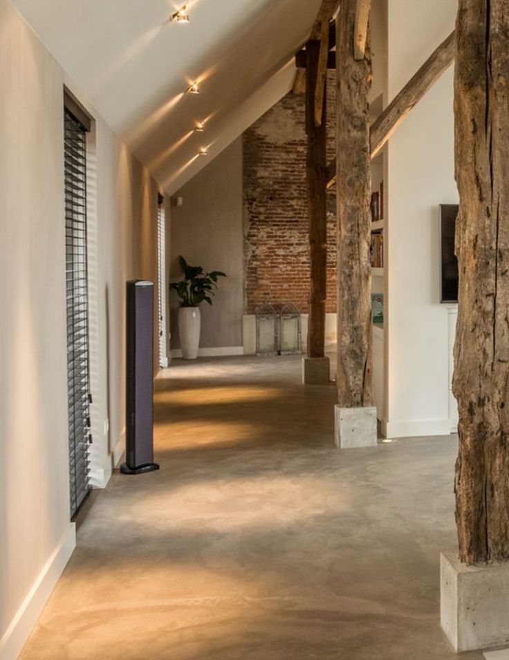 an empty hallway with exposed brick walls and wooden beams