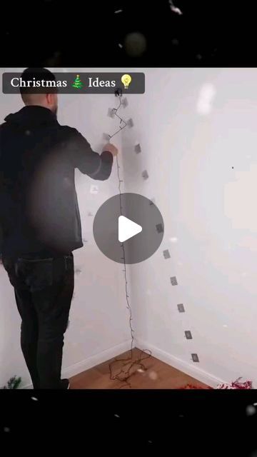 a man is painting the wall in his living room with white paint and christmas decorations