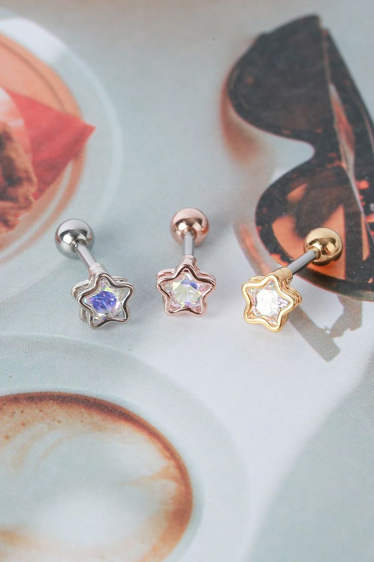 The 'AURORA STARBUST' earrings are a stunning pair of stud earrings that feature a starburst design with a sparkling cubic zirconia stone in the center. The stone is set in a hollowed-out star-shaped clasp and the design is reminiscent of a burst of light, just like the stunning aurora borealis. These earrings are small in size, making them perfect for everyday wear, but the sparkly design is sure to catch the eye of anyone who sees them. Please note that the clasp on these earrings is designed Sparkling Star-shaped Crystal Earrings, Silver Star Crystal Earrings, Silver Star-shaped Crystal Earrings For Pierced Ears, Star-shaped Crystal Earrings For Party, Silver Star Crystal Earrings For Pierced Ears, Star-shaped Cubic Zirconia Earrings With Star Charm, Star-shaped Cubic Zirconia Earrings For Party, Star Shaped Cubic Zirconia Earrings For Party, Burst Of Light