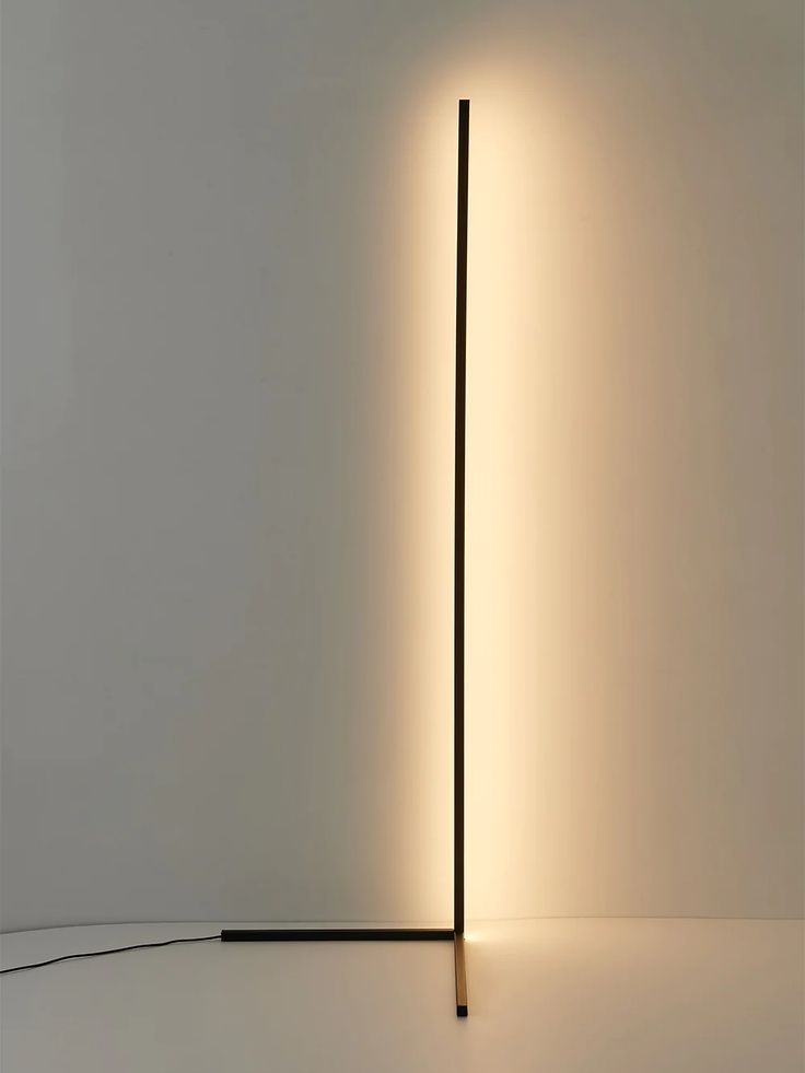 a light that is on top of a floor next to a wall with a lamp in it