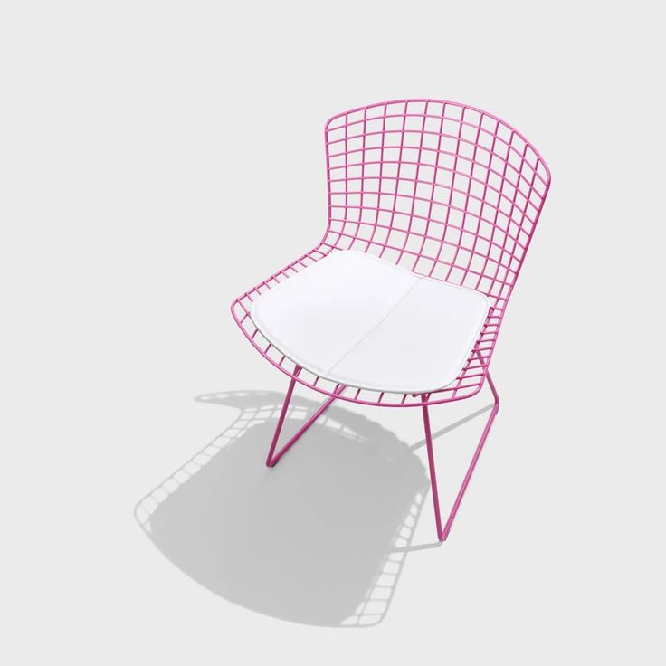 a pink and white chair sitting on top of a floor