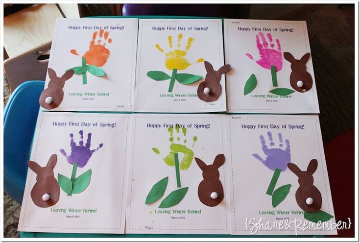 four handprints with flowers on them sitting on top of a blue chair in front of a table