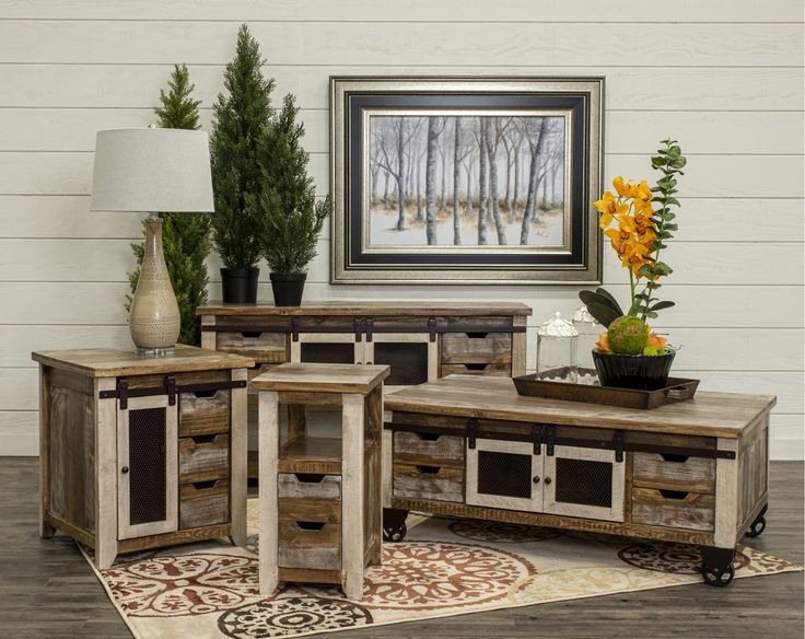 three pieces of furniture sitting on top of a rug in front of a painting and lamp