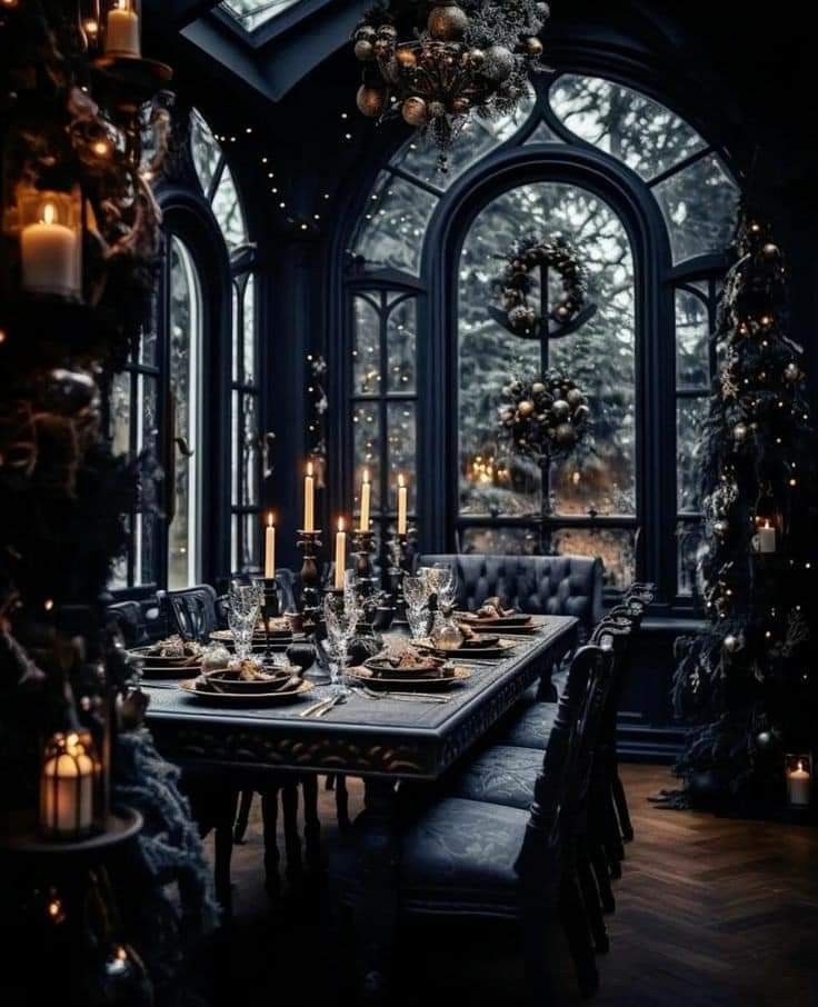 a dining room table set for christmas dinner with candles and wreaths hanging from the ceiling