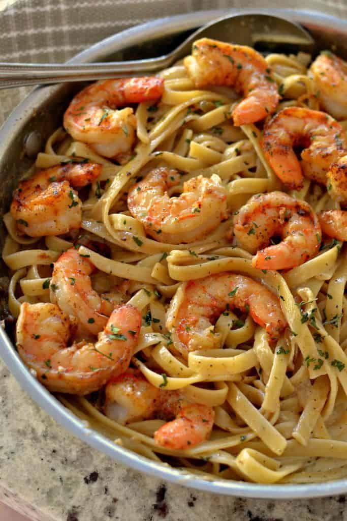 a bowl filled with pasta and shrimp on top of a table