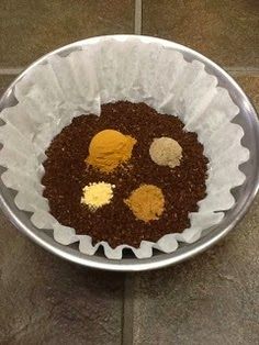 a metal bowl filled with food on top of a tiled floor