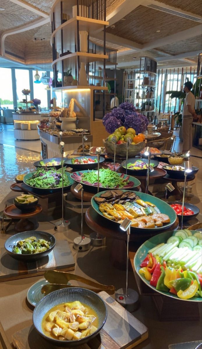 the buffet is full of many different types of food on plates and serving utensils