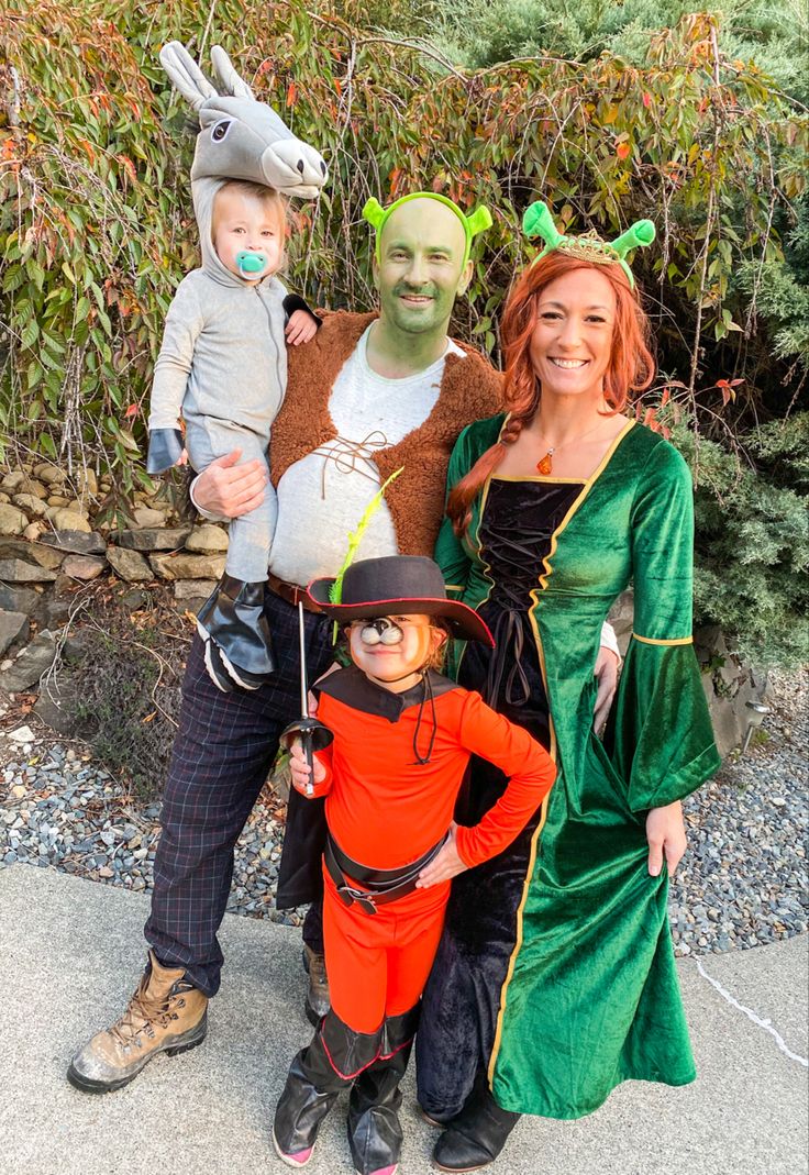 three people in costumes posing for a photo with a child and an adult wearing a costume