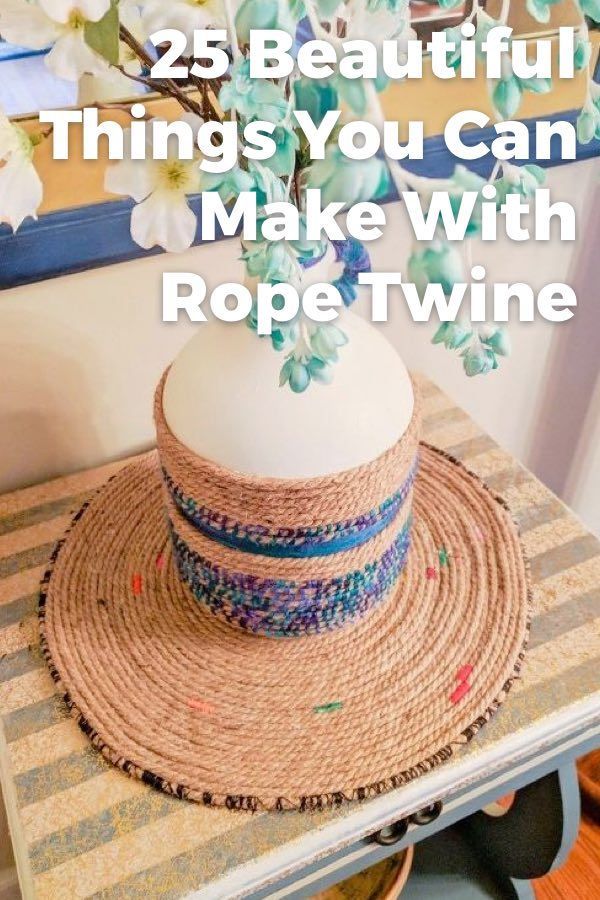 a hat sitting on top of a table next to a vase with flowers in it