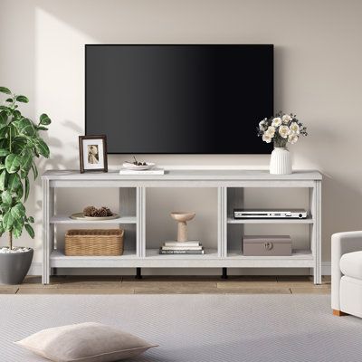 a living room with a couch, chair and large television on the wall above it