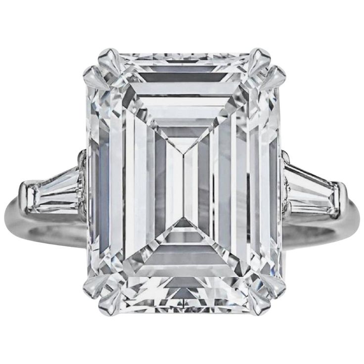 an emerald - cut diamond ring with baguets on the shoulders