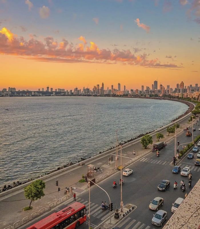 an aerial view of a city street with cars and buses on the road next to the water