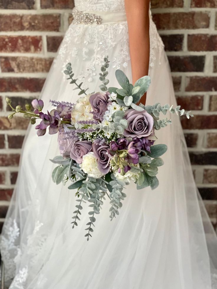 the bride is holding her purple and white bouquet