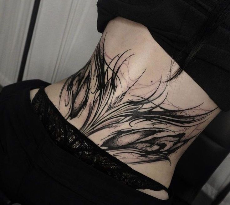 the back of a woman's neck with black feathers on it