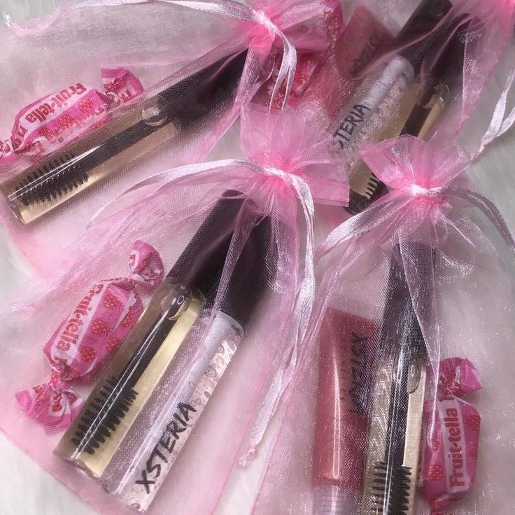 four lipsticks wrapped in plastic bags with pink bows