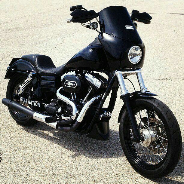 a black motorcycle parked on top of a parking lot