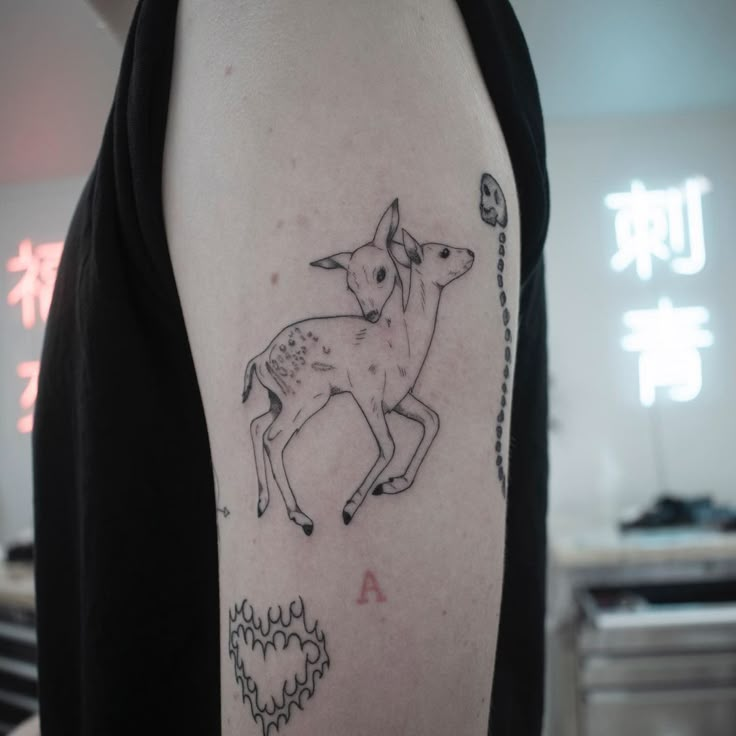 a person with a tattoo on their arm that has an image of a deer in it