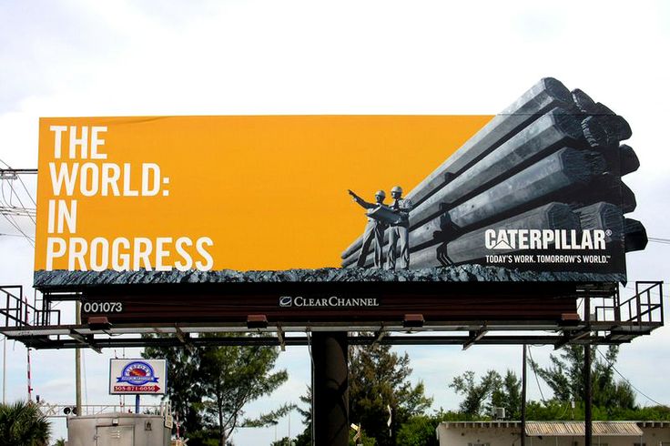 an advertisement for caterpillar is shown on the side of a building in front of trees