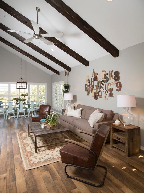 a living room filled with furniture and a ceiling fan in the middle of an open floor plan