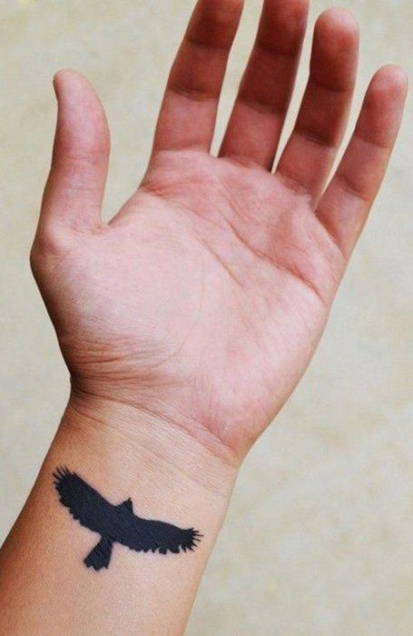 a hand with a bird tattoo on it