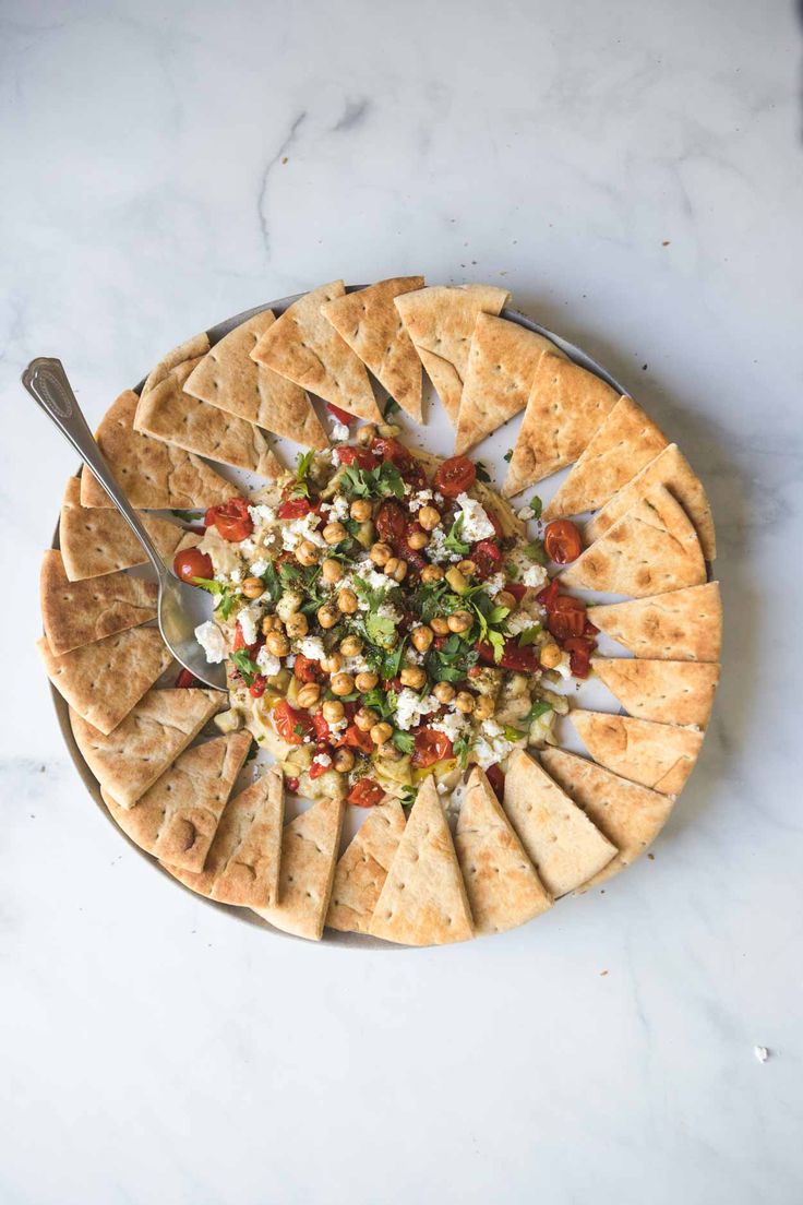 a platter with pita bread, salsa and tortilla chips on it