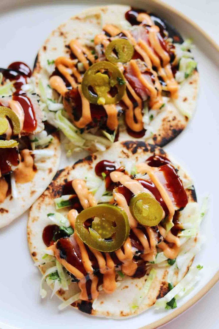 three tortillas topped with cheese and jalapenos on a white plate