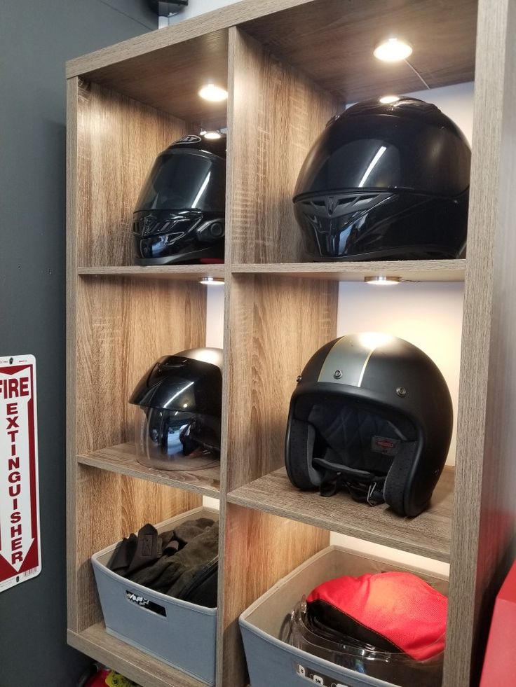 several different types of helmets on shelves in a room