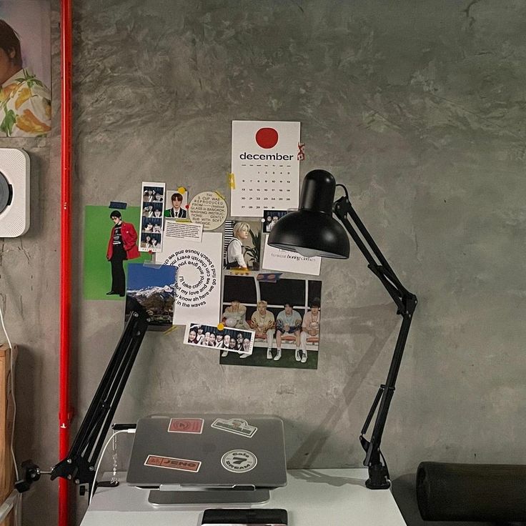 a desk with a lamp and pictures on the wall