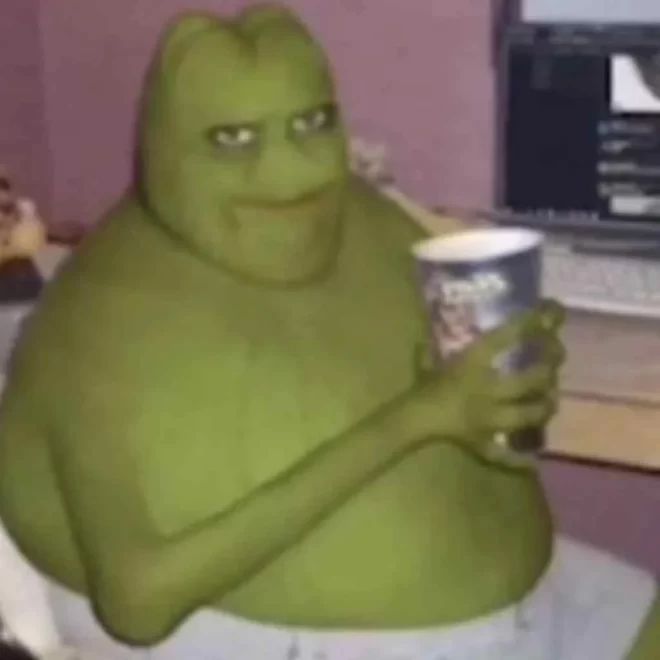 a large green creature holding a drink in front of a computer