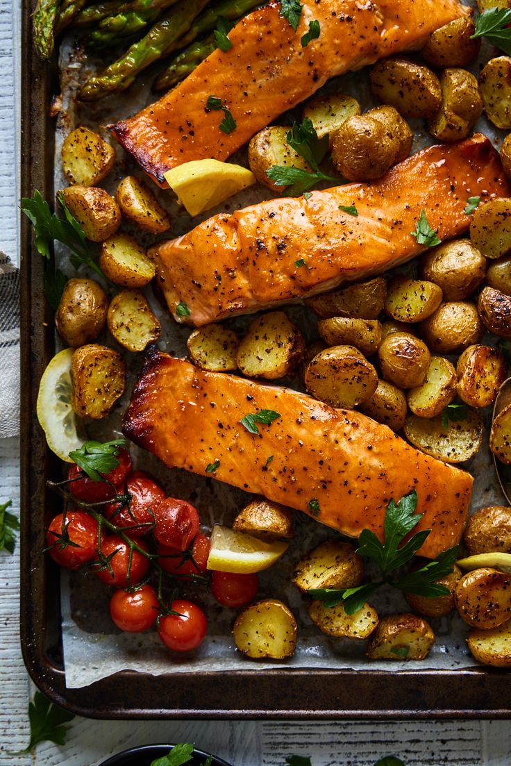 salmon, potatoes and asparagus on a baking sheet