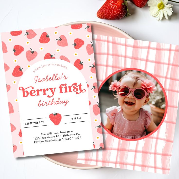 a strawberry first birthday party card on a plate