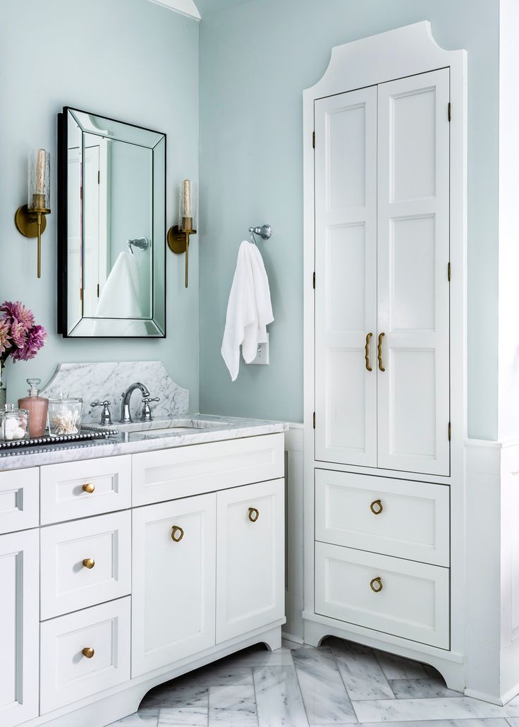 a bathroom with white cabinets and marble counter tops, along with an advertise for the