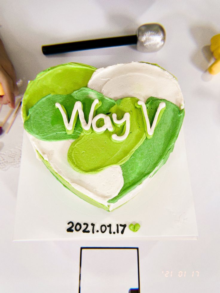 a cake shaped like a heart with the word way on it and green leaves in the shape of a heart