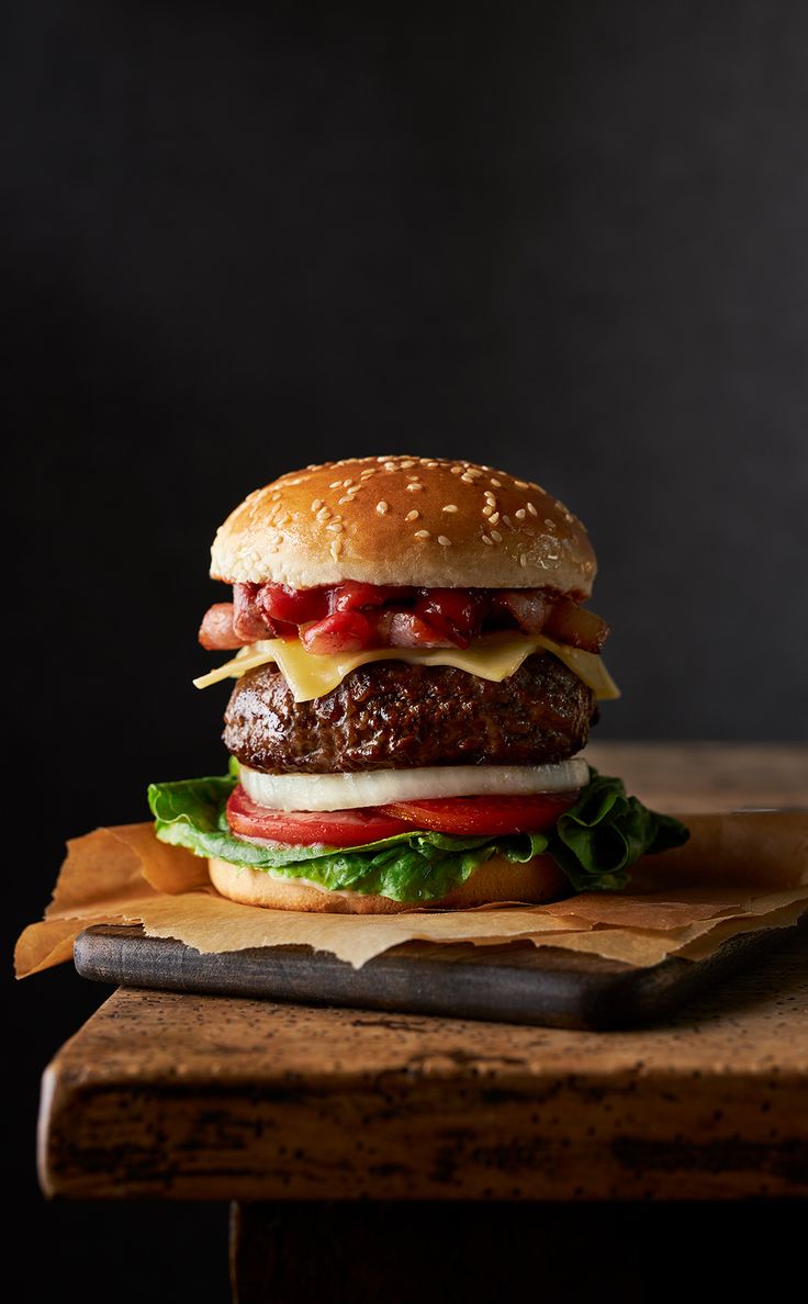 a hamburger sitting on top of a wooden cutting board