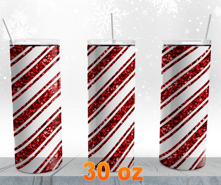 three tall red and white christmas candles with snowflakes on the top, in front of a snowy background