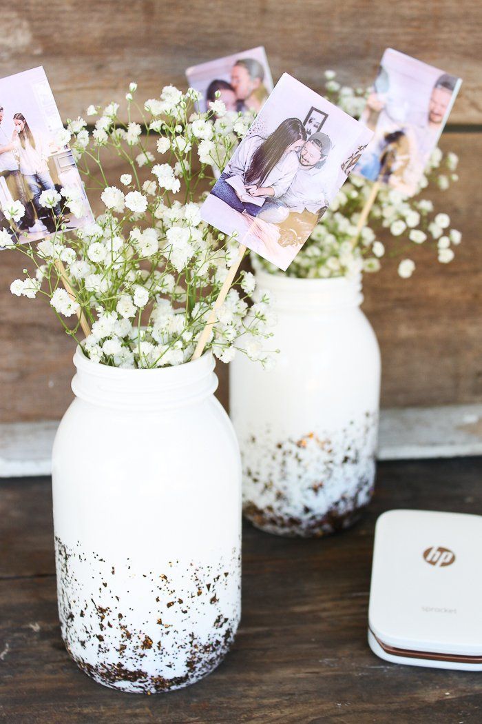 two mason jars filled with baby's breath flowers on top of a wooden table